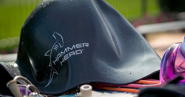Black Hammer Head Swimming Cap on top of other swim gear. safe swim caps, water safety, water, pool, summer, compete, swim coach, summer, protection