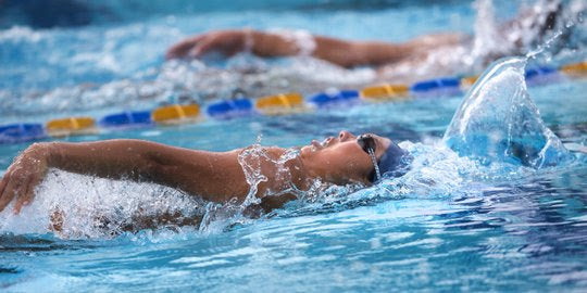 Dr. Sandra Harrell swimming competitively in an NCAA swim competition