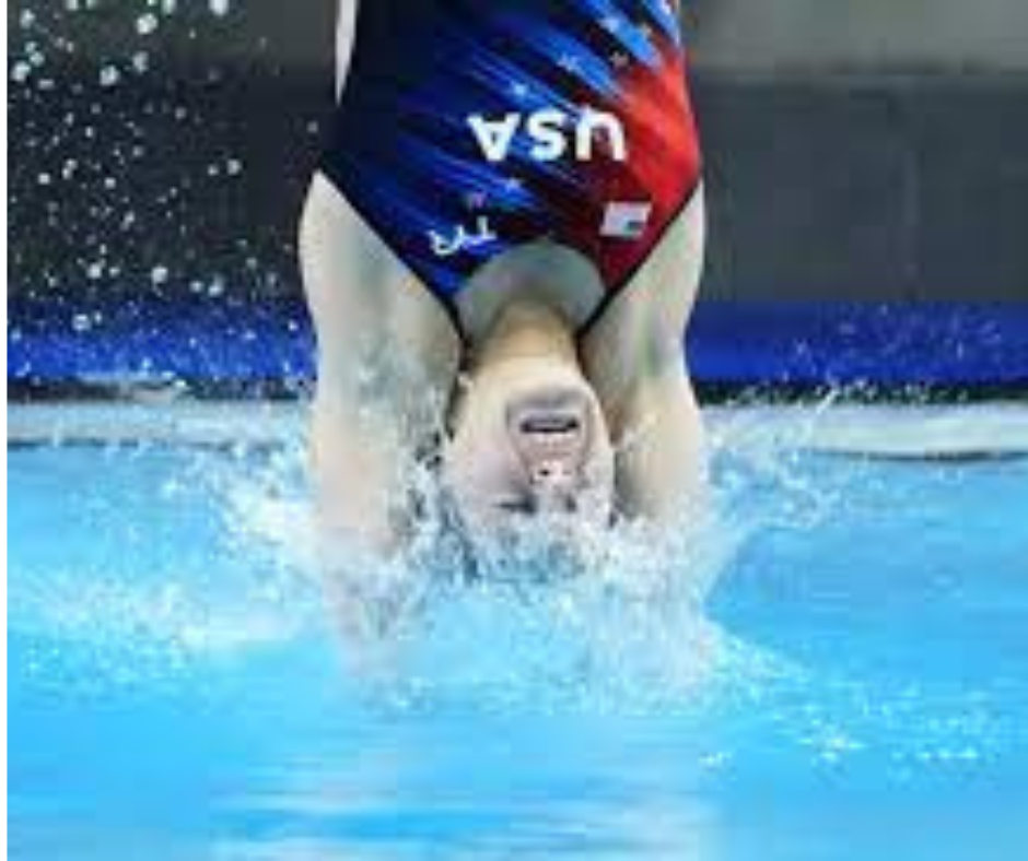 Swimmer in a pool wearing a swimsuit with 'USA' branding. This diver is entering the pool with imperfect form which can cause head injury. Divers should wear protective swim caps to minimize injury. You can also have swim caps with extra comfort. 