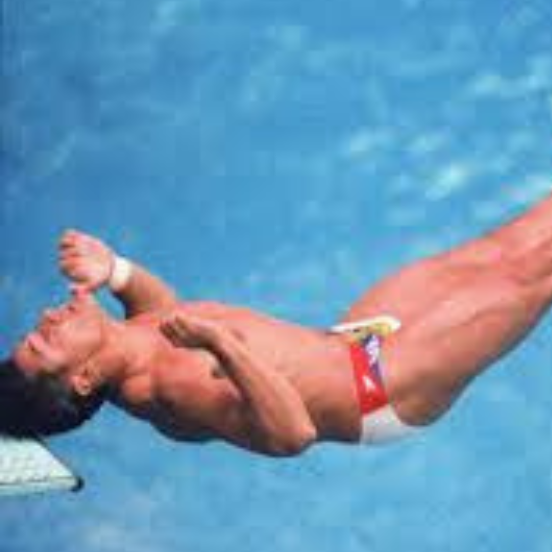 Person diving into a pool with clear blue water hits his head on the spring diving board. He should be wearing a concussion prevention swim cap like Hammer Head. These silicone swim caps are comfortable and offer swim gear for head protection like a helmet.