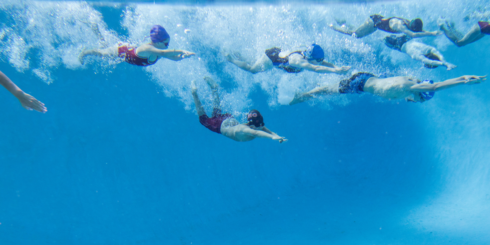 Swimmers in a pool with clear blue water
