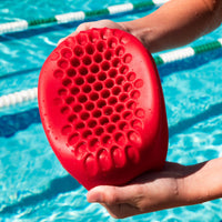 Inside of red hammer head swim cap with swimming pool in background. Ideal as a youth swimming cap, adult swimming cap, women's swimming cap and men's swim cap. Safety cushion inside is in picture to protect from head injuries.