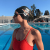 This female artistic swimmer is wearing the black Hammer Head Swim Caps - Safe Swim Cap for Adults and Youth, 50% Safer and 100% more Durable with 365-Day Guarantee, Approved by Olympians, Parents, Artistic Swimmers and Coaches. Hammerhead swim caps is a waterproof swim cap, qualifies for custom swim caps with three size options and delivers athletes protective swim caps.